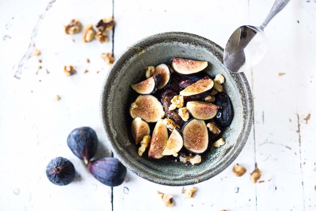 Teff Porridge with Figs in ceramic bowl, whole figs displayed beside bowl