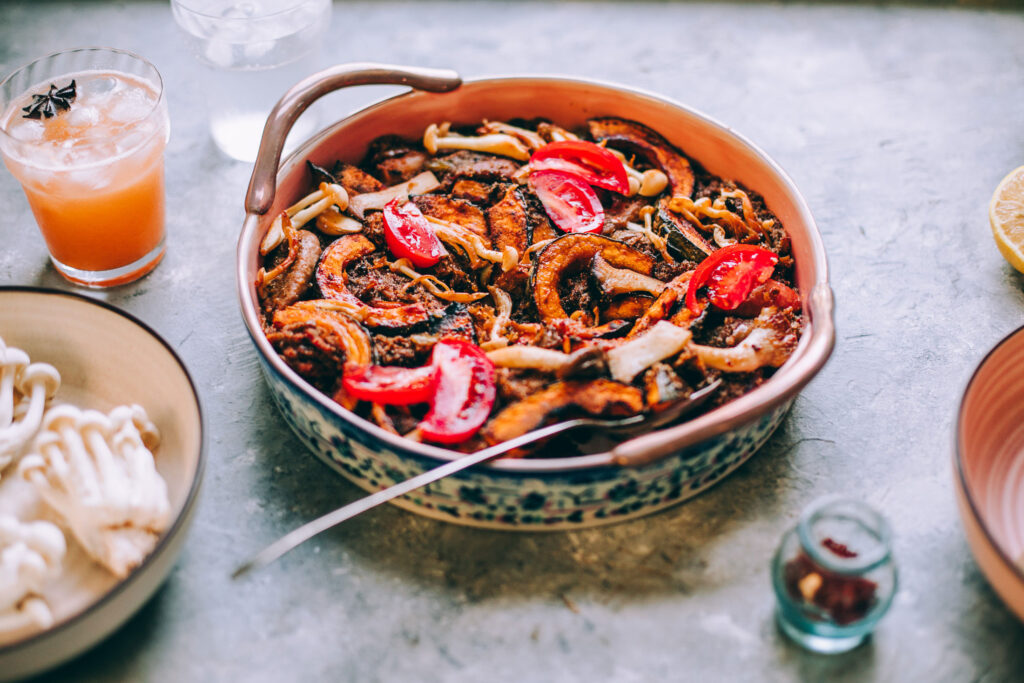 Gluten-Free Paella Recipe with Fall Veggies in a bowl with other dishes