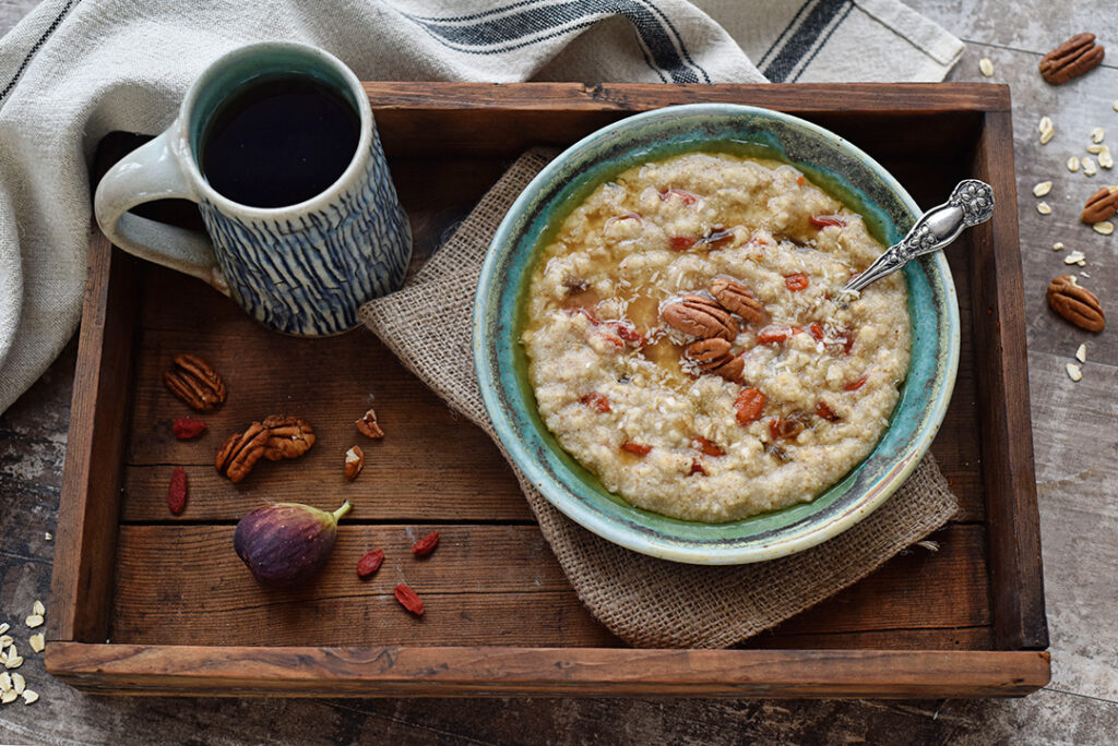 Gluten-Free Porridge with Goji Berries in bowl on wooden tray