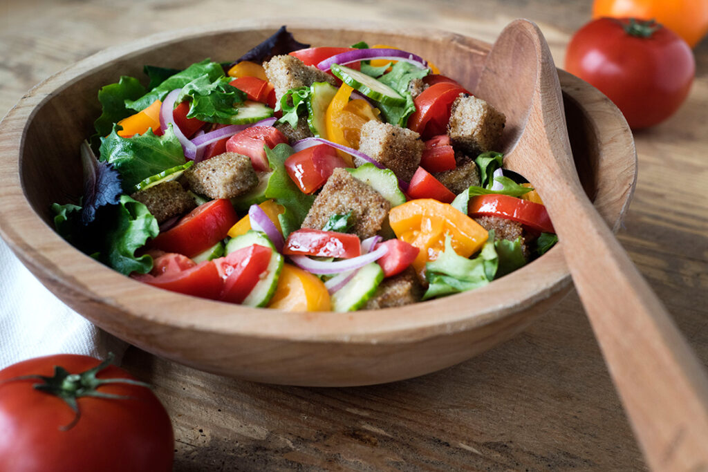 Summer Whole Grain Salad with colorful vegetables in wooden bowl