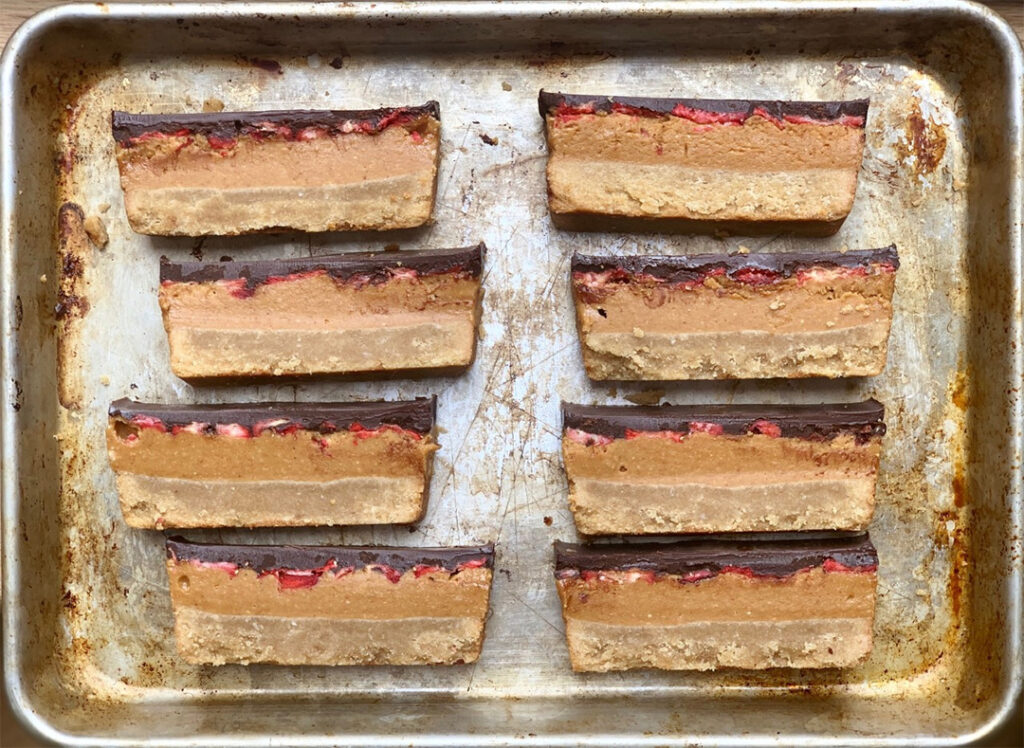 Gluten-Free Strawberry Slice displayed showing layers of peanut butter, strawberry and chocolate