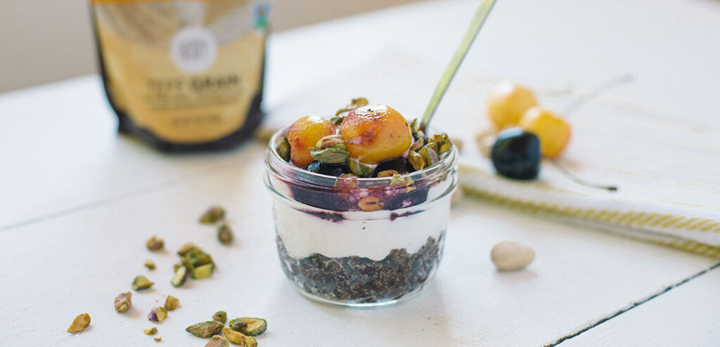 Gluten-Free Broiled Cherry Teff Parfait in glass bowl with layers