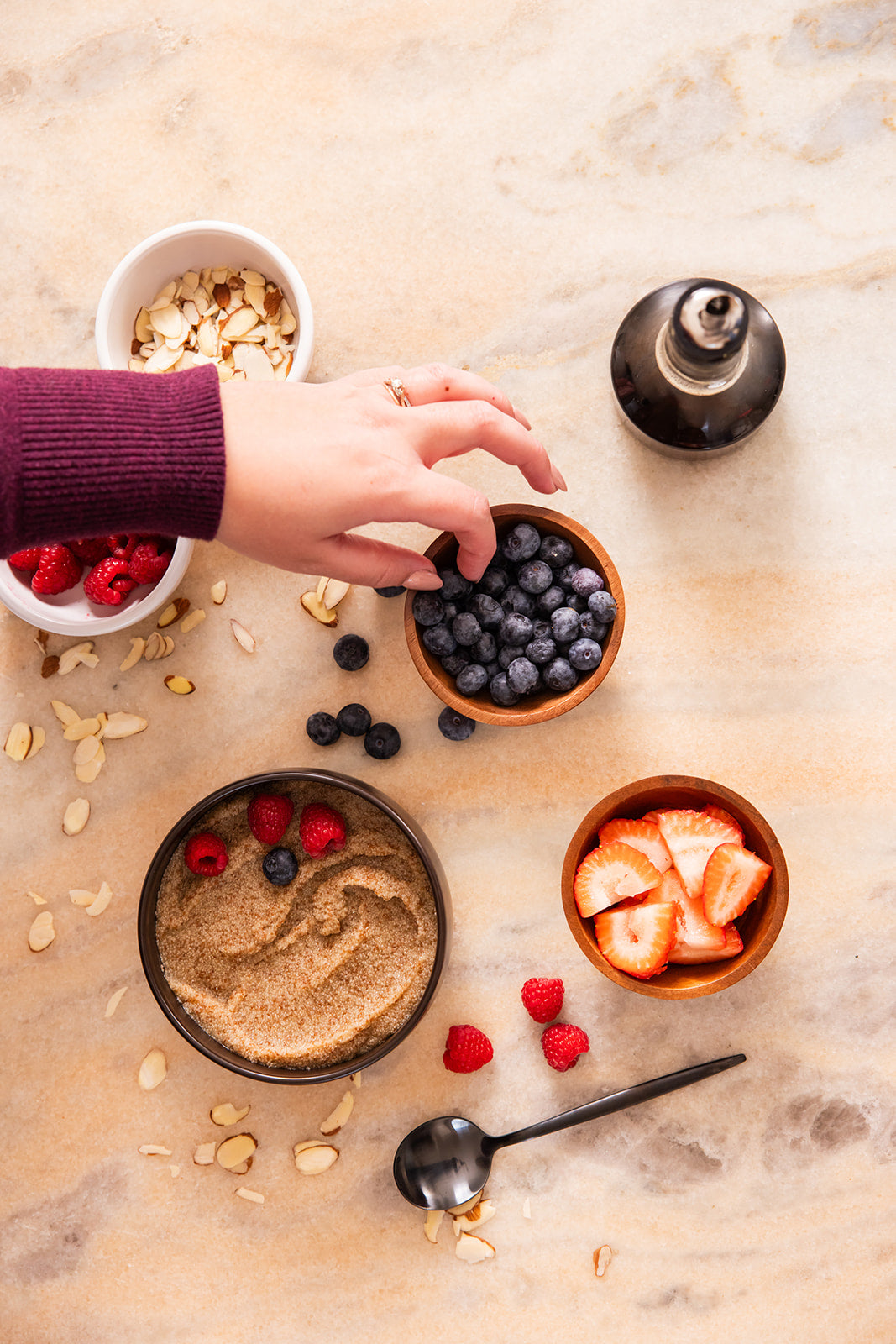 Person preparing a breakfast with various ingredients on a marble surface